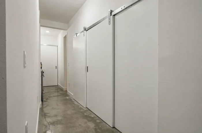 Cuisine en couloir avec porte coulissante blanche remplaçant une porte battante, libérant visuellement l'espace et facilitant la circulation